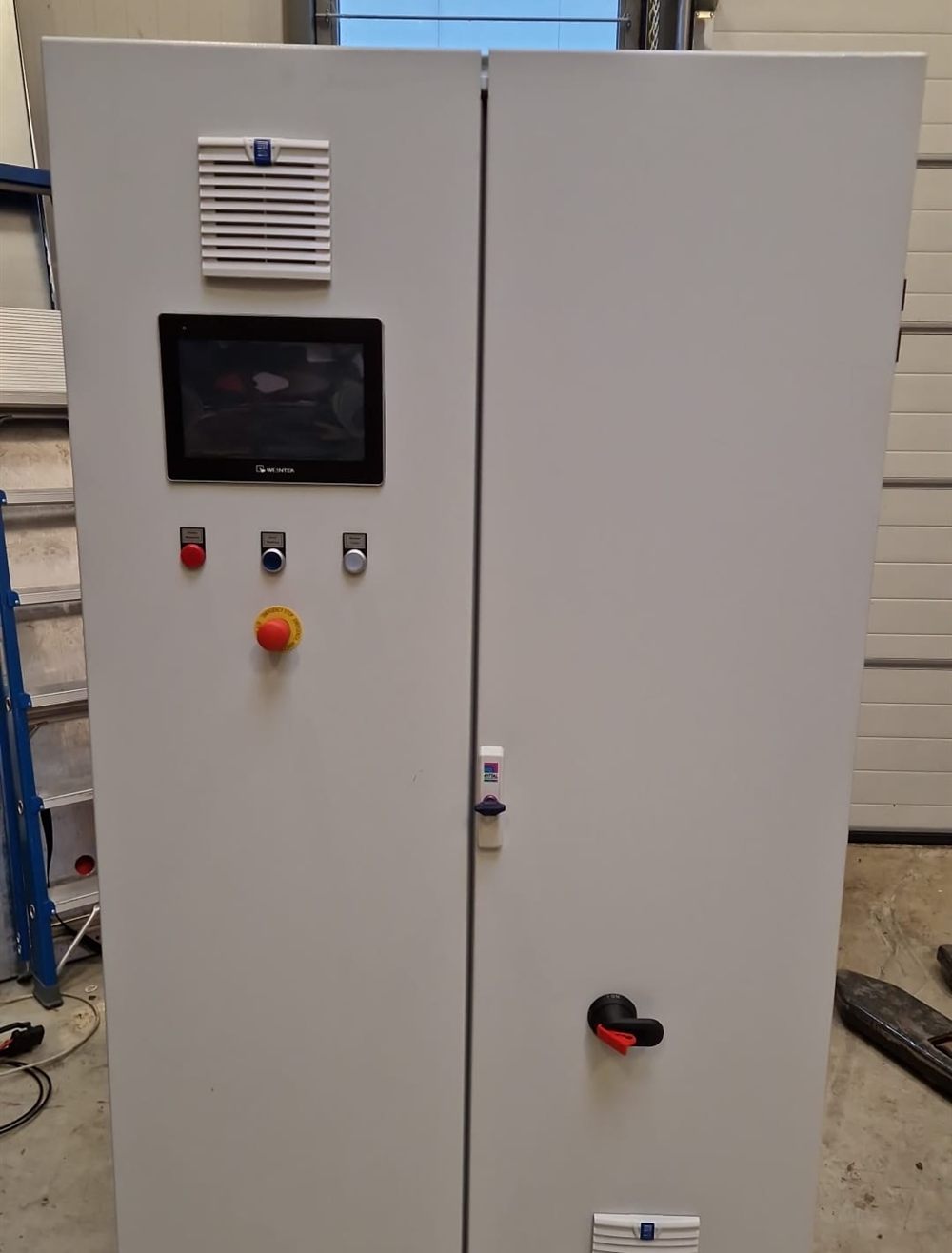Opgeleverde dubbeldeurs besturingskast van Prime Solutions met touchscreen, bedieningsknoppen, noodstop en hoofdschakelaar